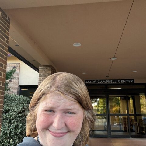 Olivia smiling in front of the Mary Campbell Center
